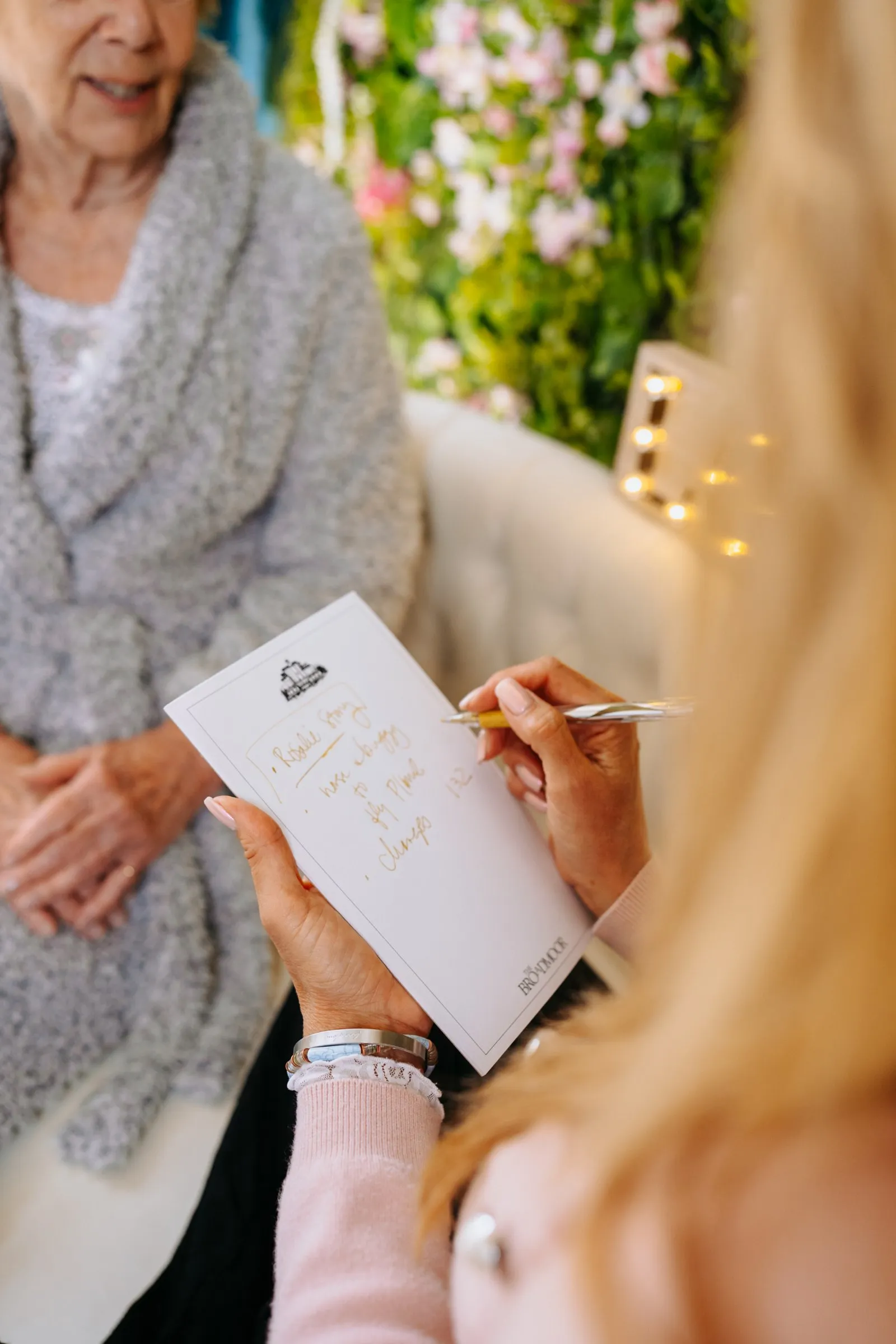 Michelle writing notes on a card while listening to a client